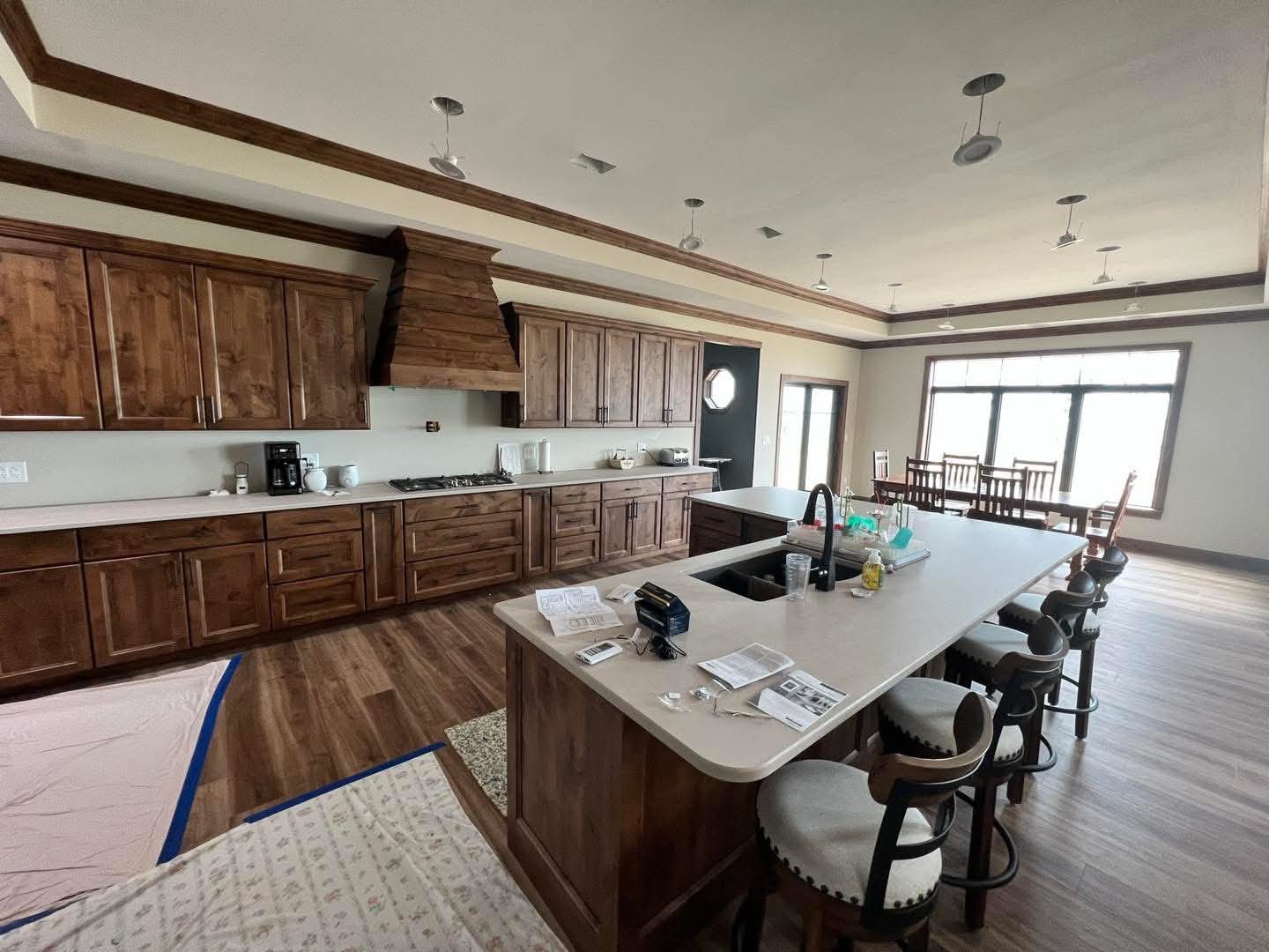 Finished kitchen with rich stained cabinetry, custom range hood, and granite island