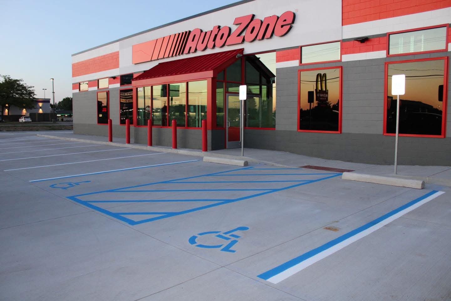 Fresh blue ADA parking striping and lane lines at an AutoZone storefront