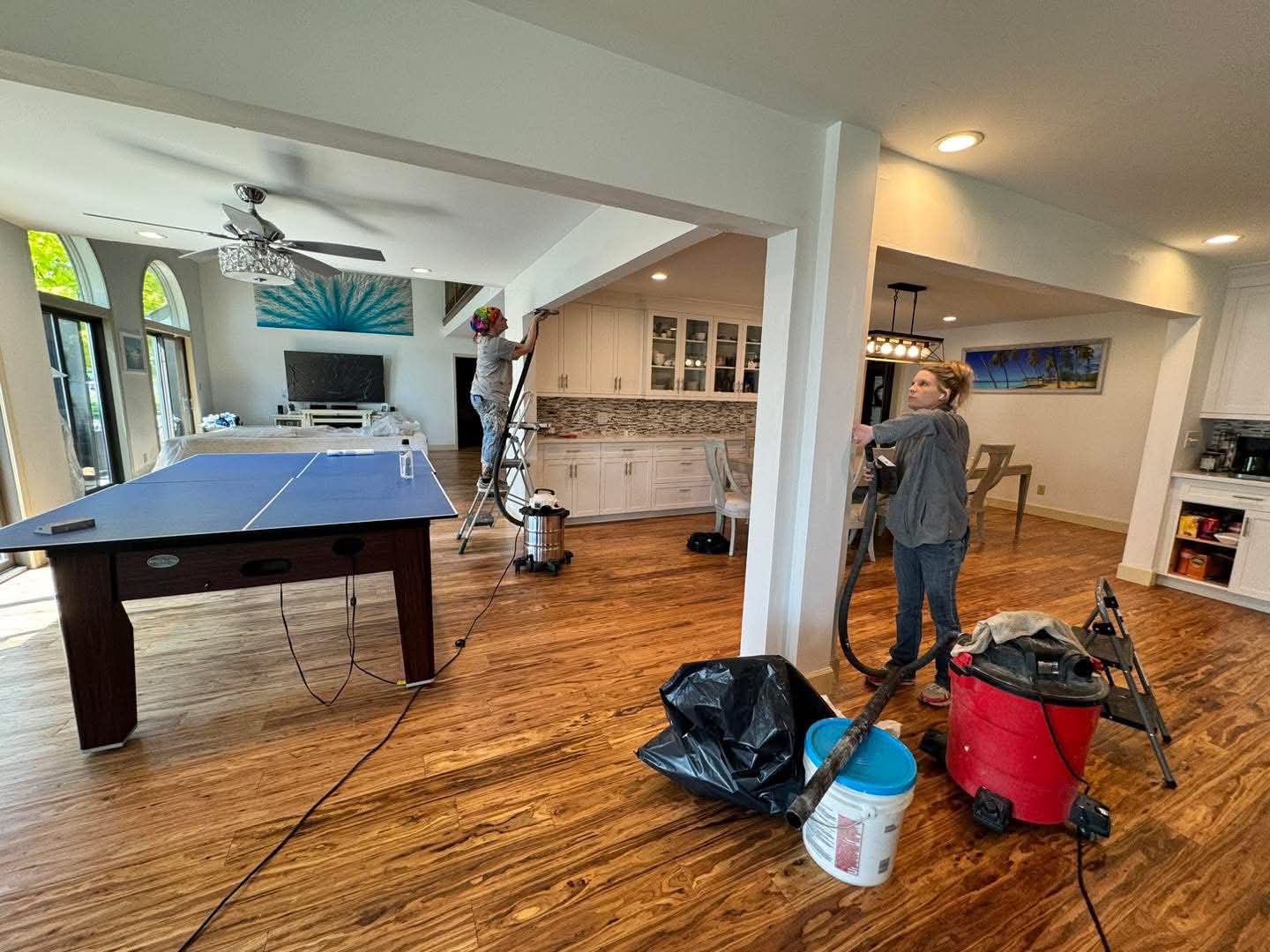 S&S crew wrapping up cleanup with a shop vac after a flooring and ceiling job