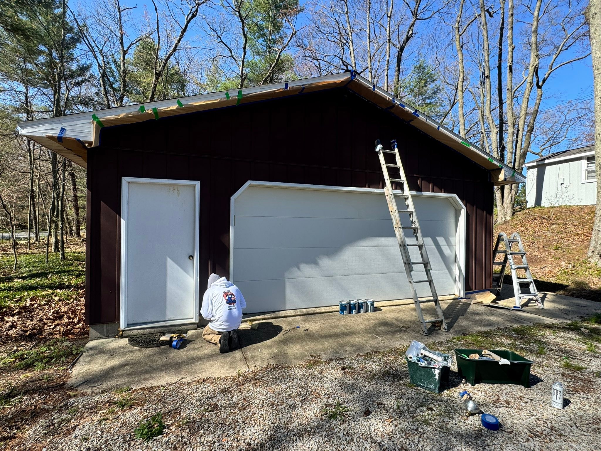 Exterior garage repaint with freshly installed white doors — prepped, primed, and painted in under two hours